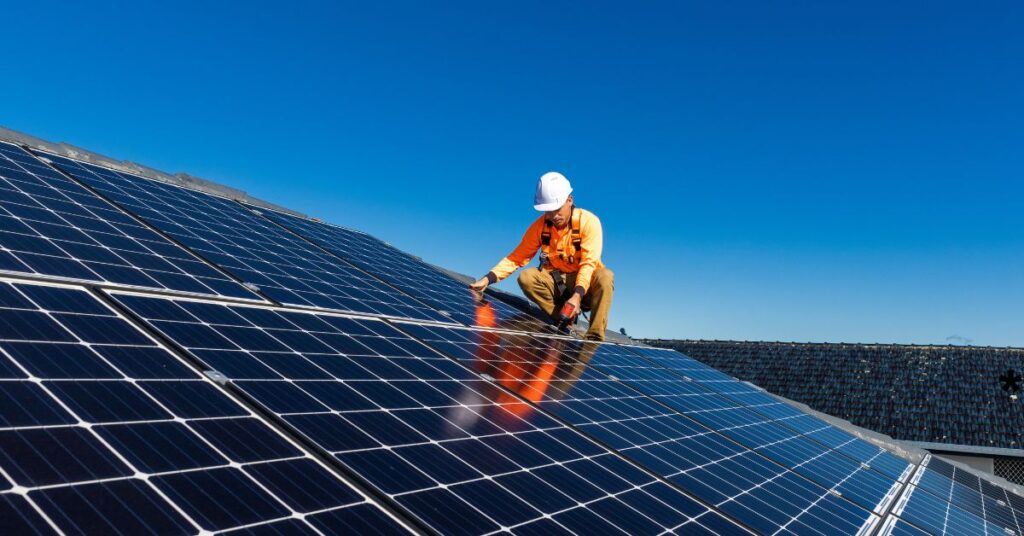 a man install solar panels at roof